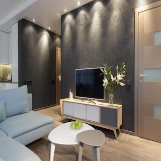 Living Room Showcasing A Chalky Black Accent Wall With Overhead Spot Lighting