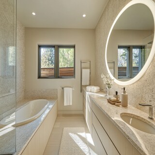 Modern Bathroom Design with Cove-Lit Oval Mirror and Granite Vanity