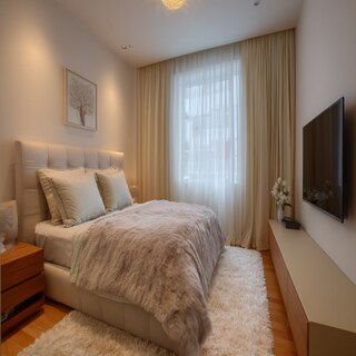 Modern Bedroom Design With A Fabric Cushioned Bed And A Beige TV Unit