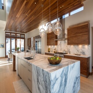 Modern Island Kitchen Design with Dramatic Veined Countertop and Backsplash