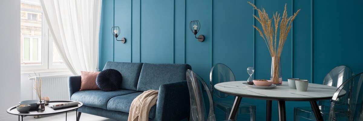 Small Teal Living Room Design With Large Windows and Decorative Pieces